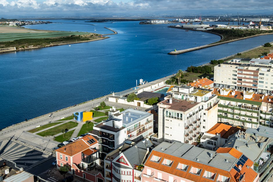 A scenic aerial view of Lisbon's riverside with colorful buildings and waterway.