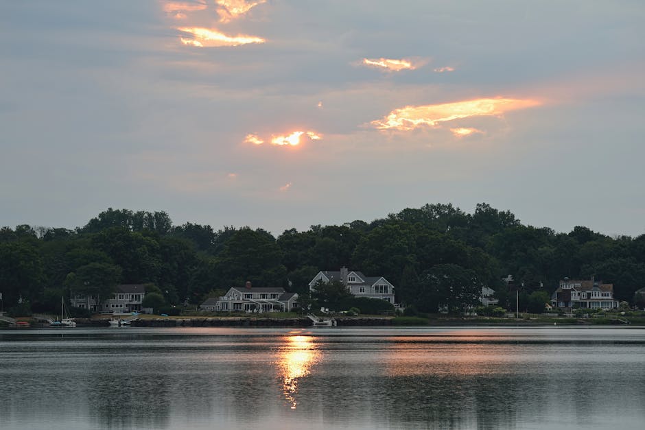 Tranquil sunset reflecting on a body of water with houses in Stamford, CT.
