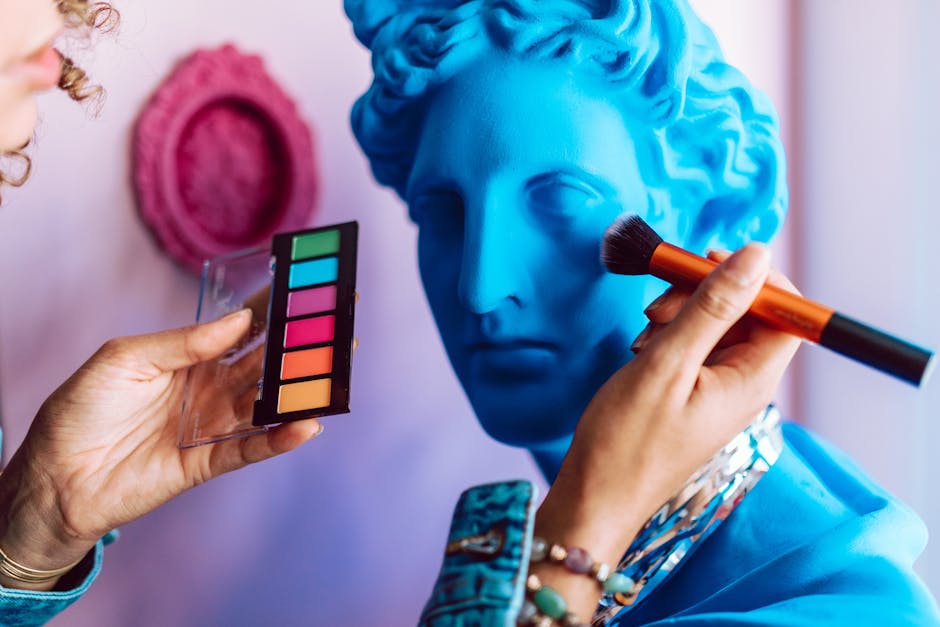 Vibrant makeup application on a blue statue bust, blending art and fashion creatively.