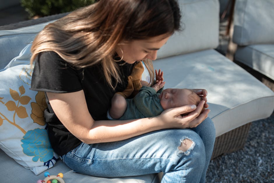 A tender moment captured as a mother cradles her newborn baby on a couch outdoors. (Photo: RDNE Stock project) A tender moment captured as a mother cradles her newborn baby on a couch outdoors.