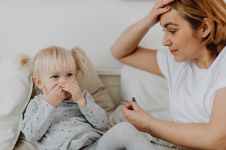 A mother and her child share a tender moment on a couch. Emotion and connection are evident.