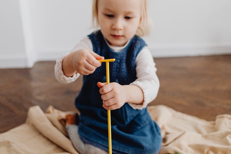 A young child playing indoors with a yellow stick, fostering creativity and imagination.