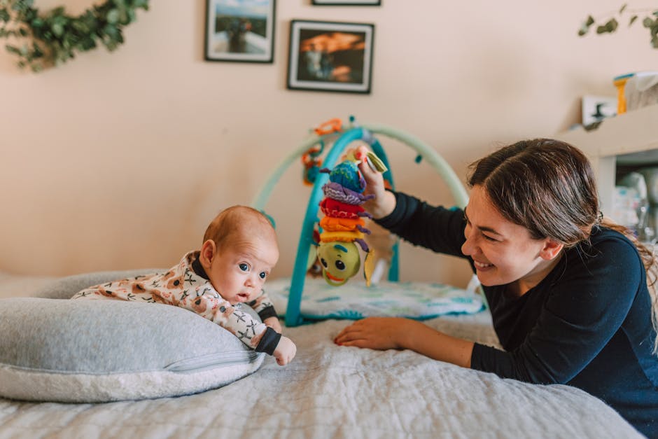 A joyful mother playing with her baby on the bed in a warm, cozy bedroom setting.