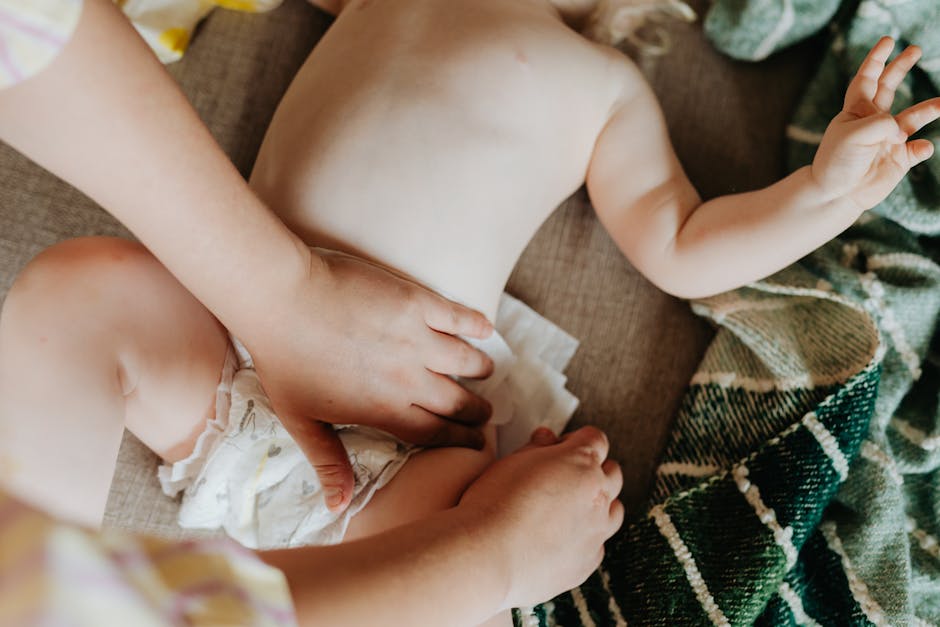 A parent changing a baby's diaper indoors, showcasing nurturing care and parenting.