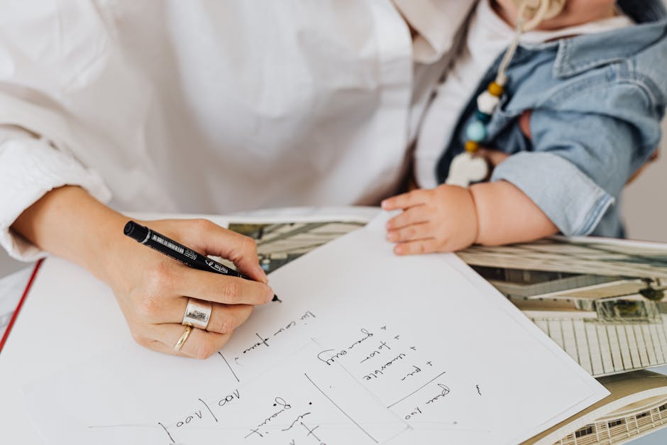 A mother working on notes while holding her baby close, illustrating multitasking.