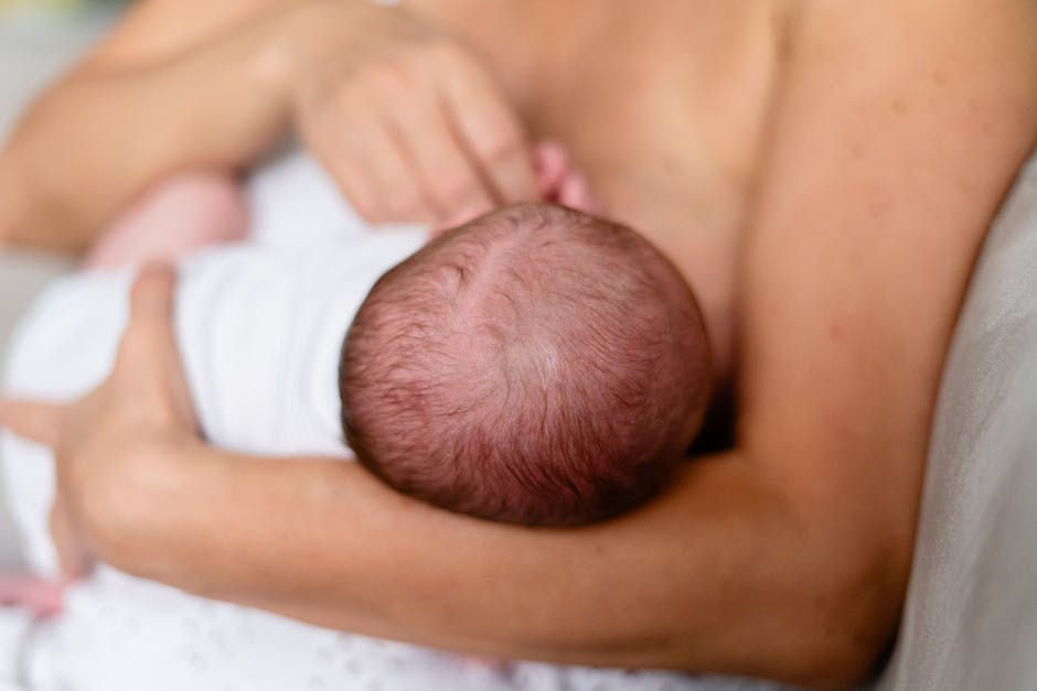 Tender moment of a mother breastfeeding her newborn, highlighting love and bonding.