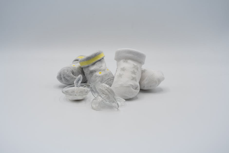 Cute baby socks and transparent pacifiers set against a clean white surface, perfect for newborn themes.