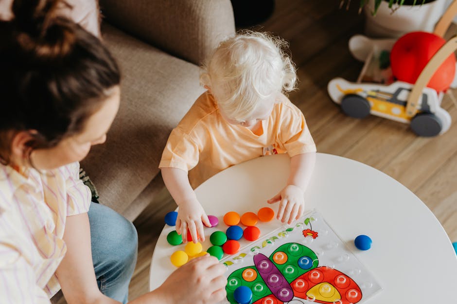A toddler playing with developmental toys on a round table with a caring mother nearby, creating a playful indoors environment.