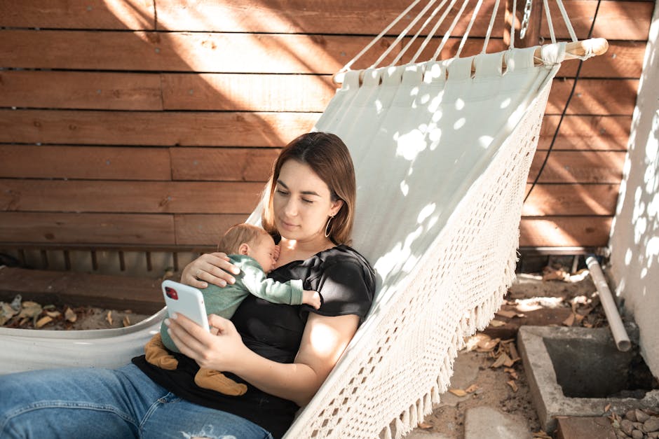 A woman relaxes in a hammock with her baby, enjoying a peaceful outdoor afternoon.