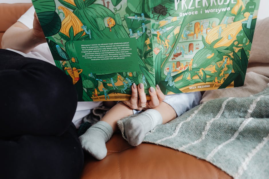 A mother and child reading a colorful book on a cozy sofa.