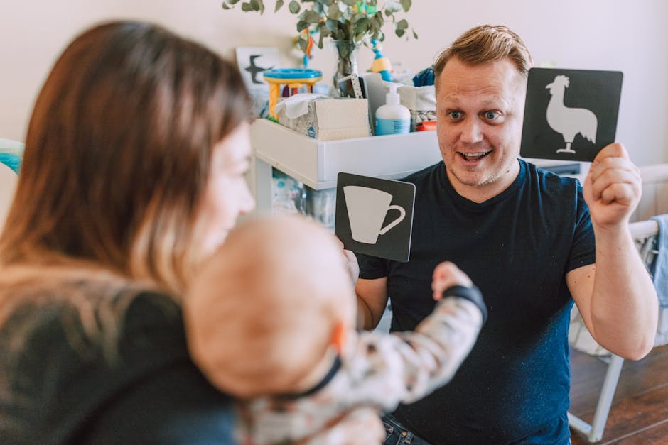 A father actively engaging with his baby using educational flash cards indoors.