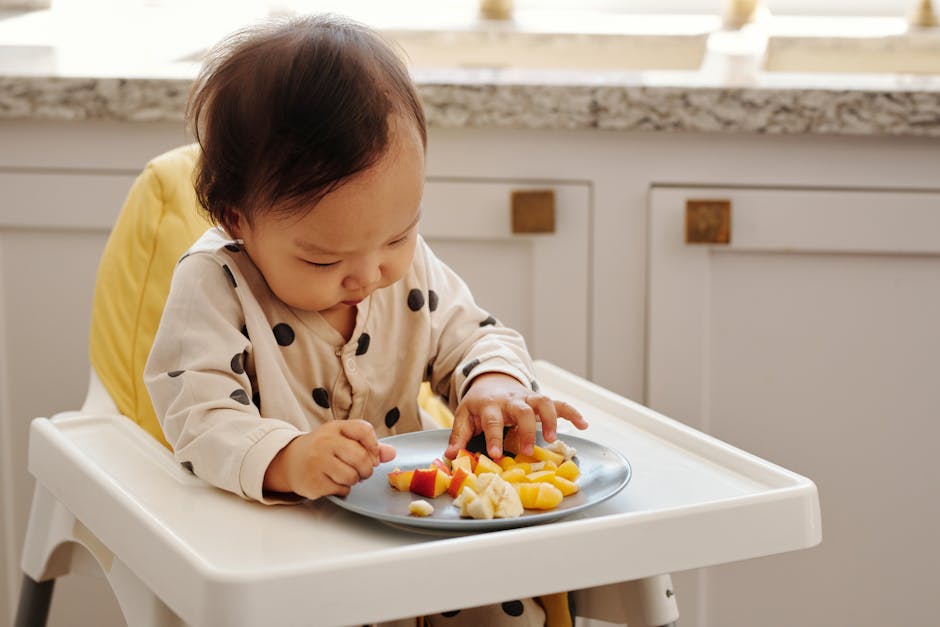 A cute toddler in a polka dot outfit enjoying a healthy fruit snack indoors.