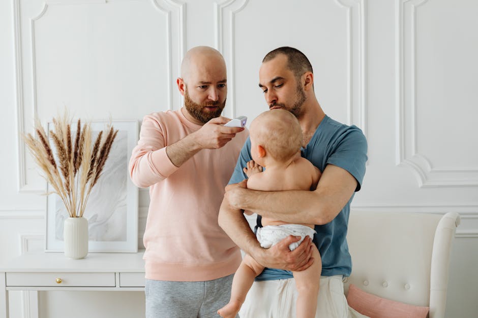 A worried father checks baby's temperature while partner holds the child at home.
